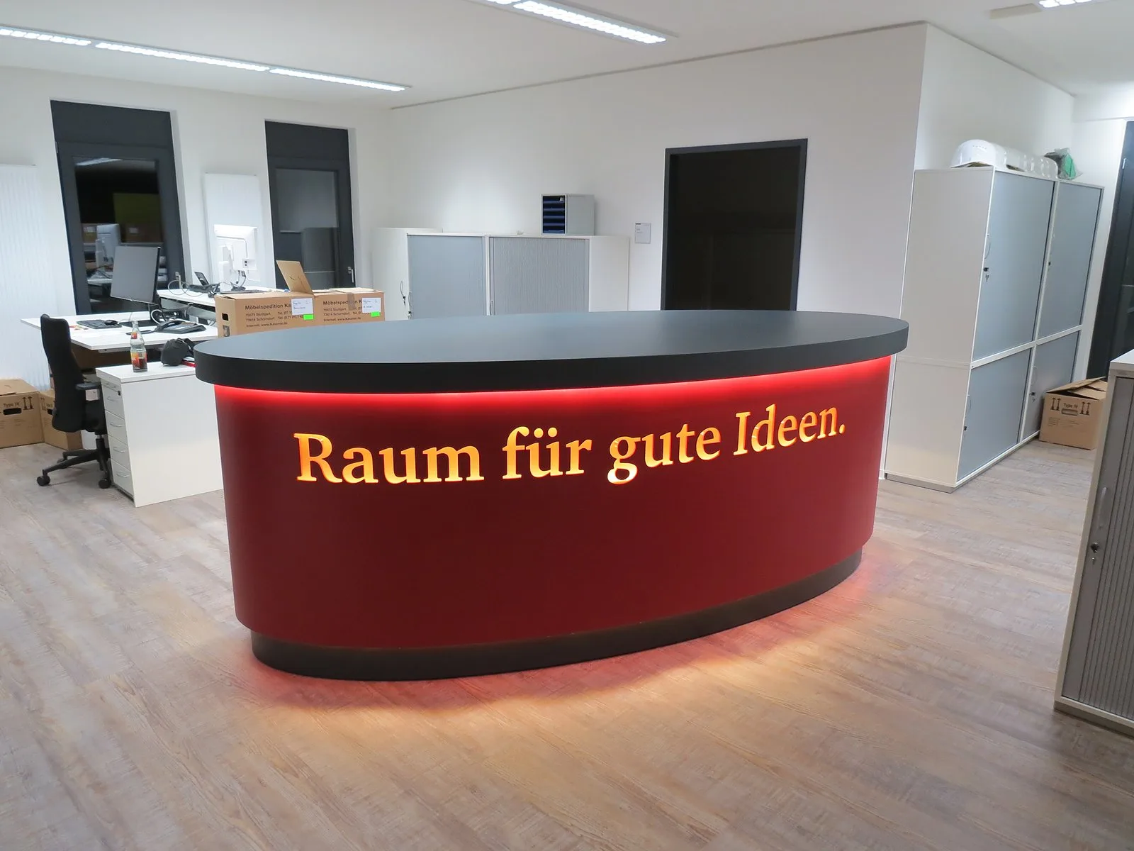 Beleuchtete rote Empfangstheke „Raum für gute Ideen“ – Sonderanfertigung der Schreinerei Hübl
